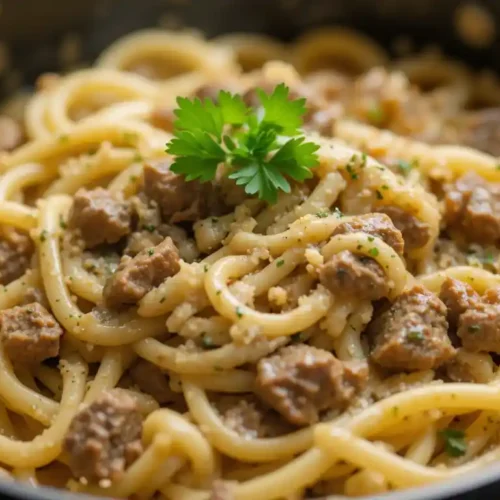 One Pot Creamy Beef and Garlic Butter Pasta 4 A close-up of creamy beef and garlic butter pasta topped with parsley in a black pot.